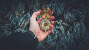 A man looking at a compass. Getting information before deciding which way to go. 