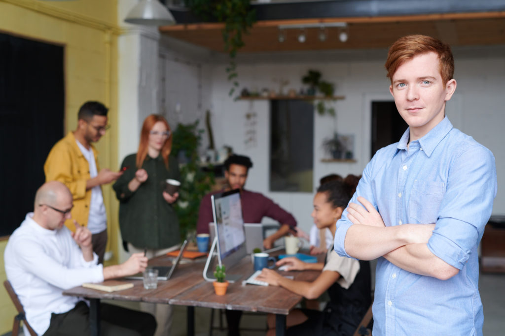 Introvert standing on front of a team meeting of 6 people.